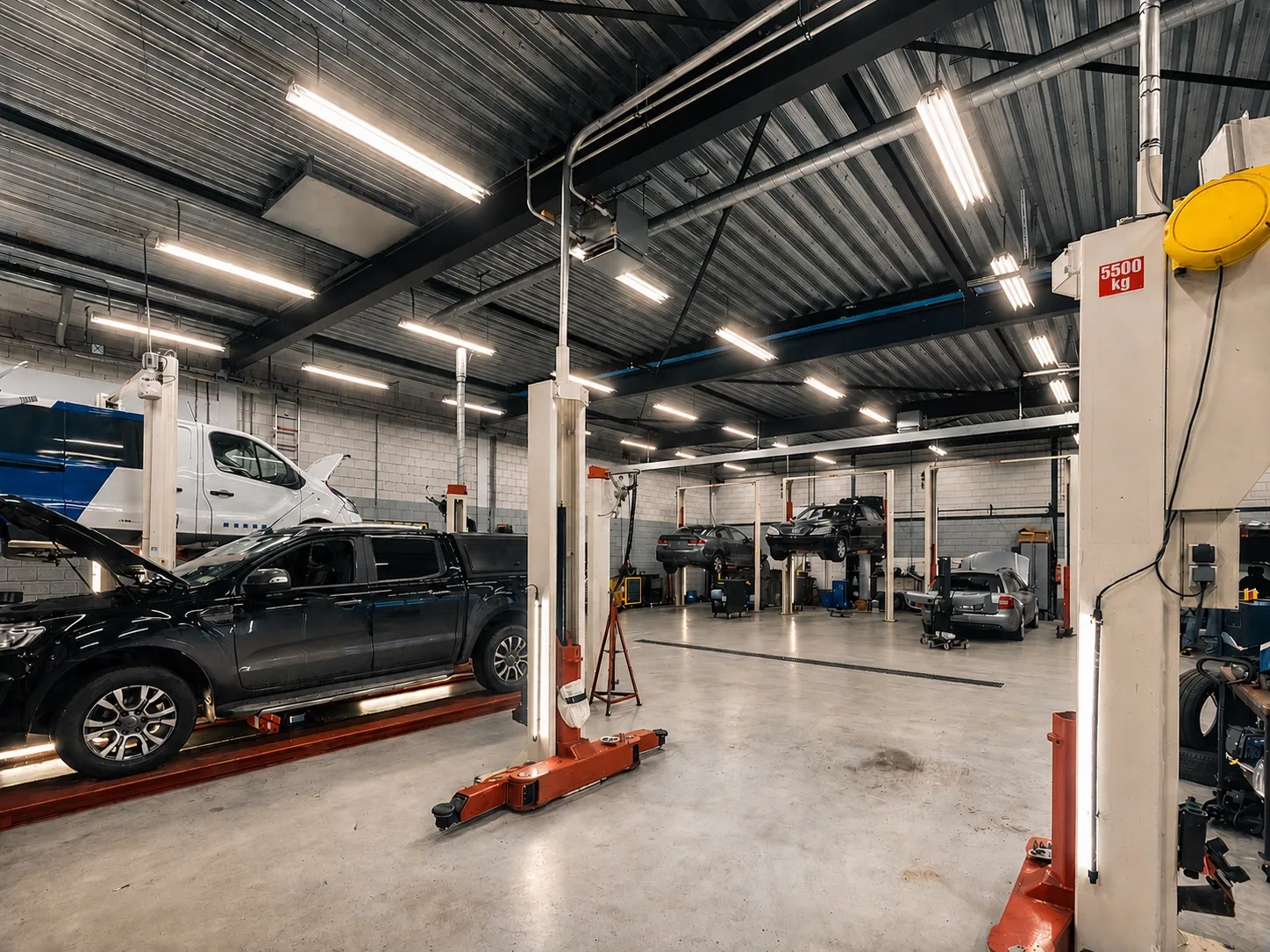 Cars raised on two-post ramps inside a garage workshop